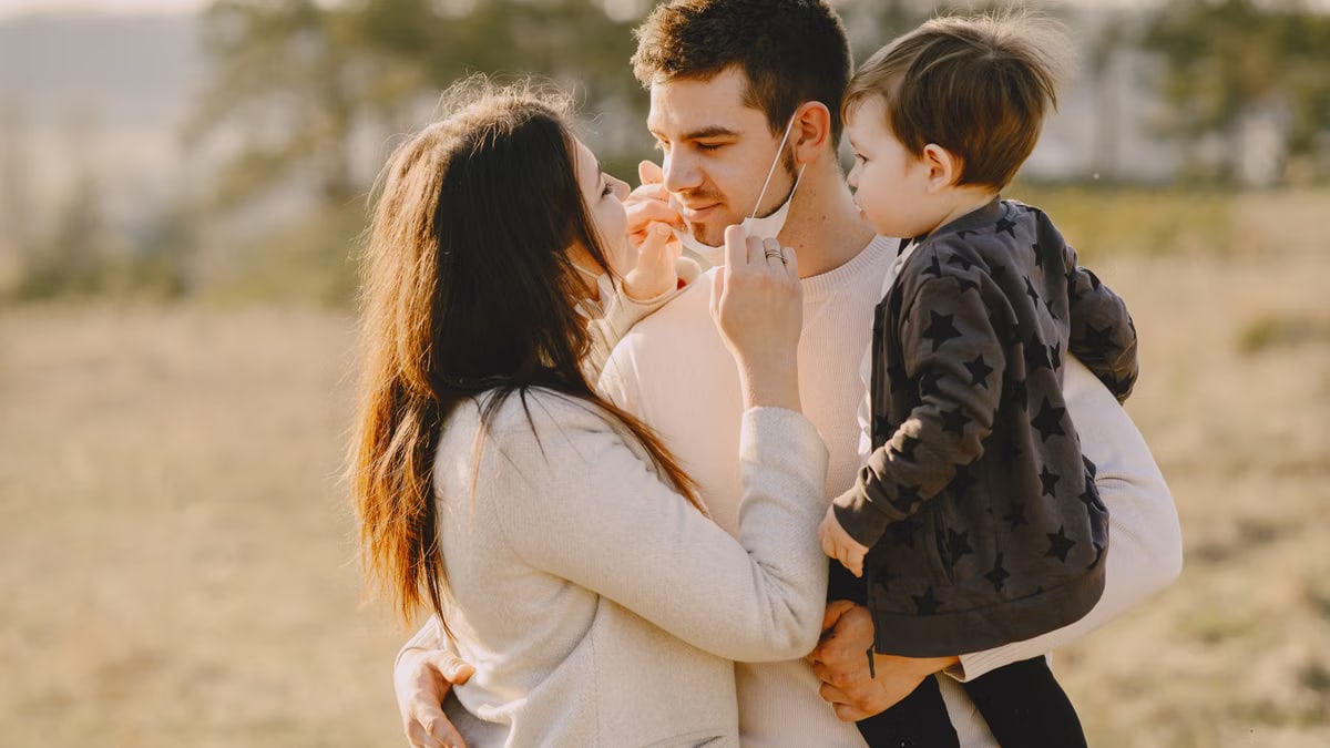 Family sharing affectionate moments outdoors with parents and child enjoying the sunny day.